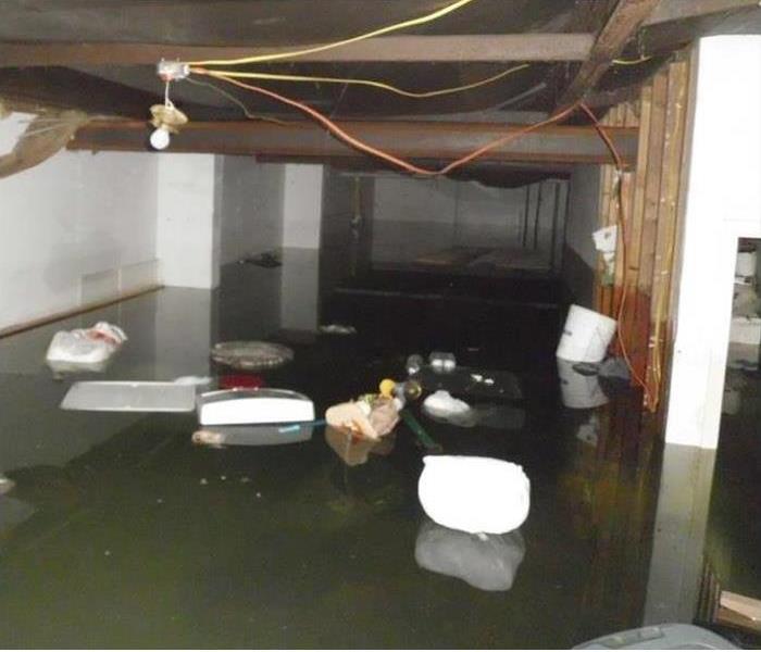 dirty floodwater in basement with contents floating on the surface