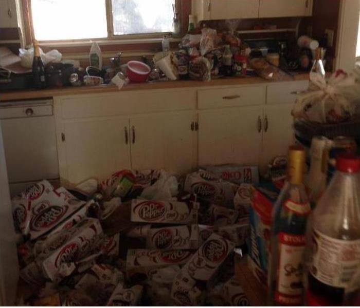 boxes, foodstuffs, bottles piled up in a kitchen--hoarding