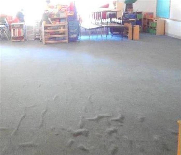 grey carpet with air blisters, toys and furniture in the background