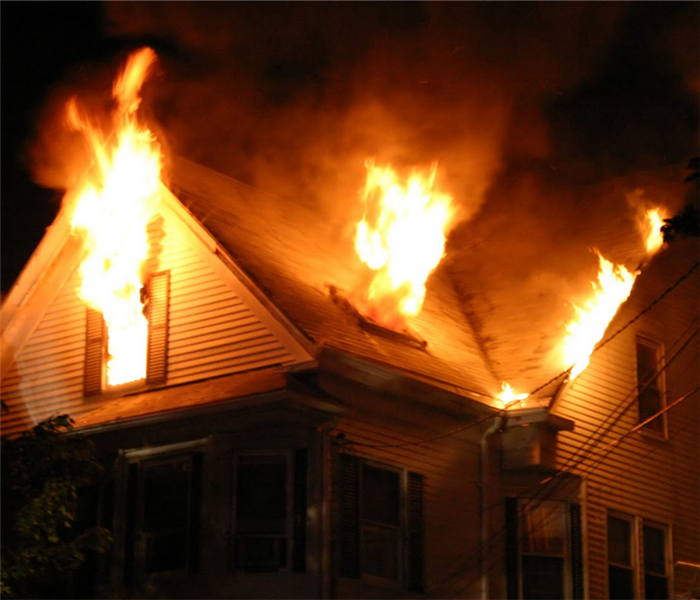 a house on fire with flames billowing out of the window